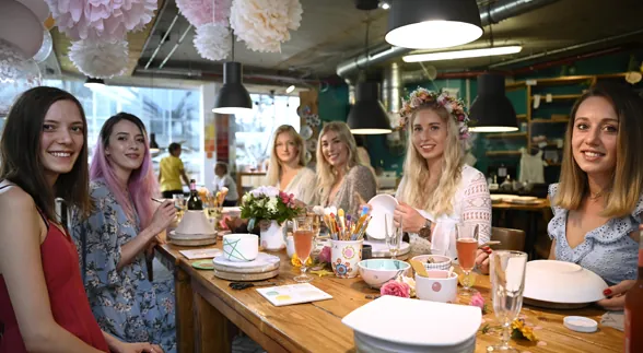 Frauen mit Blumenkränzen bemalen Keramik beim Junggesellinnenabschied