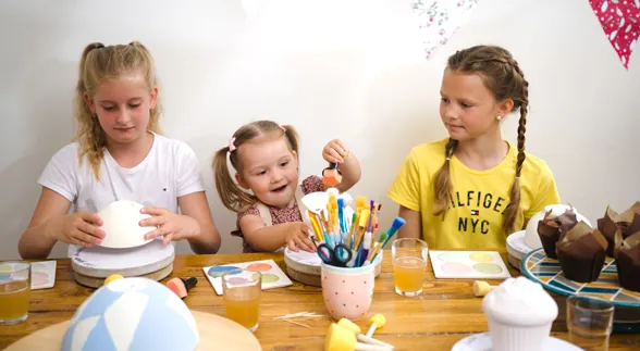 Kinder bemalen Keramik beim Kindergeburtstag