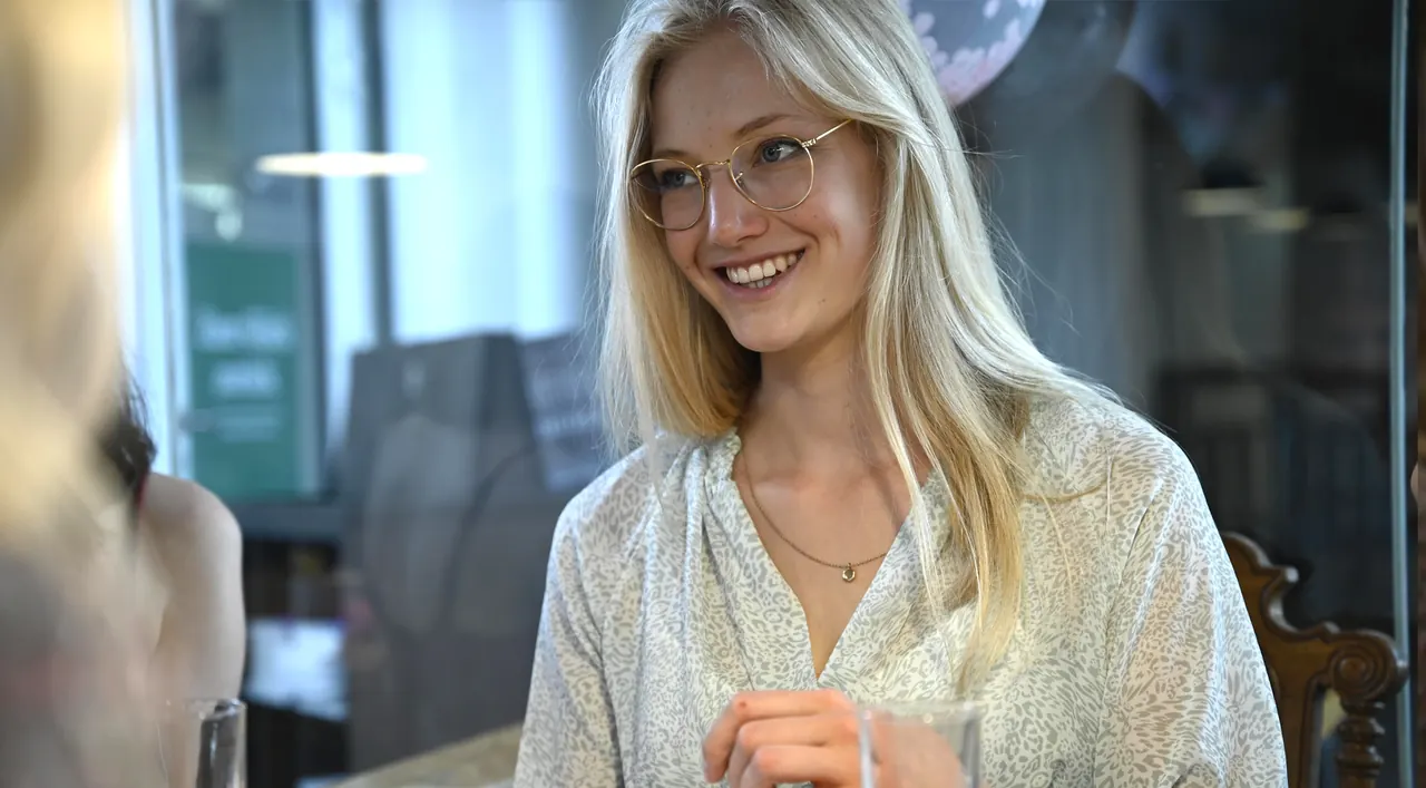 Lächelnde Frau beim Keramikmalen in der Kreativwerkstatt